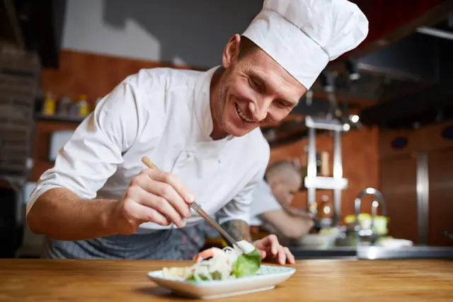 A chef plating a dish by hand